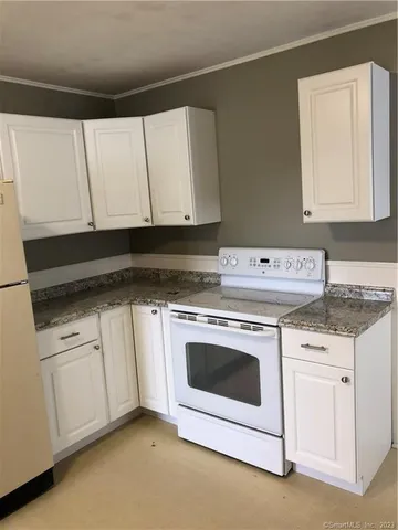 a kitchen with granite countertop white cabinets and white appliances