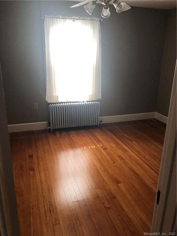 83 Ledyard Avenue Groton, CT 06340 - Photo 5 of 15 an empty room with wooden floor and windows