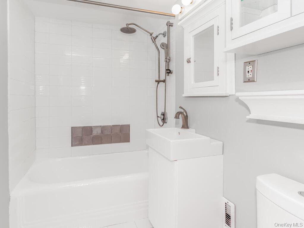 340 West 57th Street, Unit 5F Manhattan, NY 10019 - Photo 12 of 24 a bathroom with a sink a toilet and shower