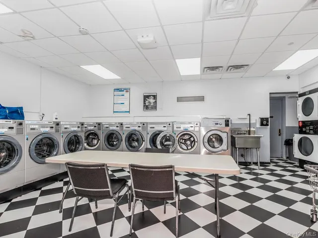 a utility room with dryer washer and a view of living room