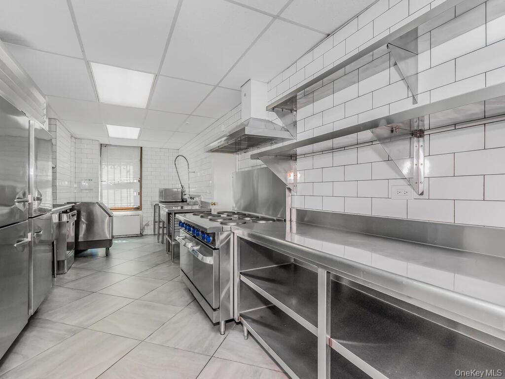 340 West 57th Street, Unit 5F Manhattan, NY 10019 - Photo 18 of 24 a kitchen with stainless steel appliances granite countertop a sink and a stove