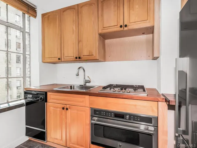 a kitchen with wooden cabinets and a stove top oven