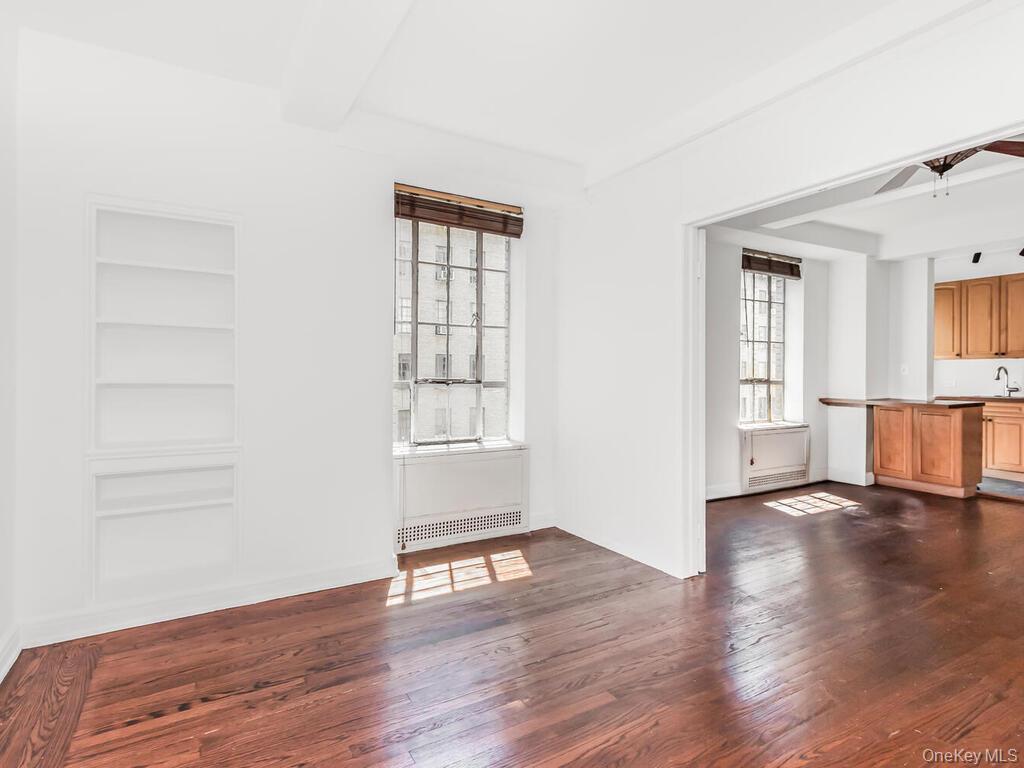 340 West 57th Street, Unit 5F Manhattan, NY 10019 - Photo 9 of 24 an empty room with wooden floor and windows