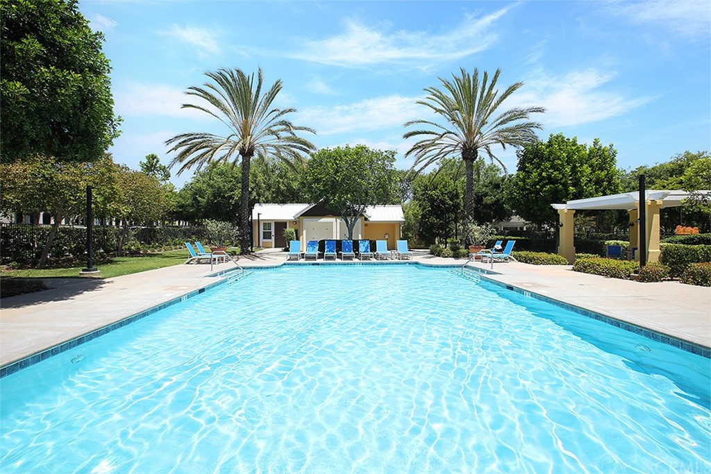 52 Palladium Lane, Unit 82 Ladera Ranch, CA 92694 - Photo 18 of 20 a view of a swimming pool with a lawn chairs and palm tree