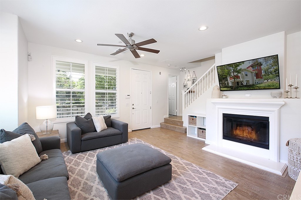 52 Palladium Lane, Unit 82 Ladera Ranch, CA 92694 - Photo 4 of 20 a living room with furniture a flat screen tv and a fireplace