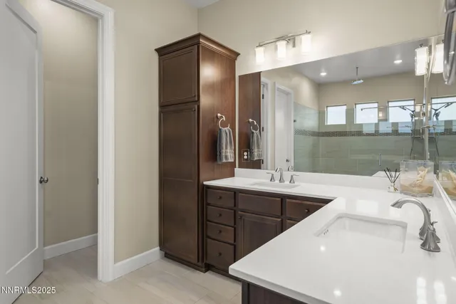 a bathroom with a double vanity sink toilet and shower