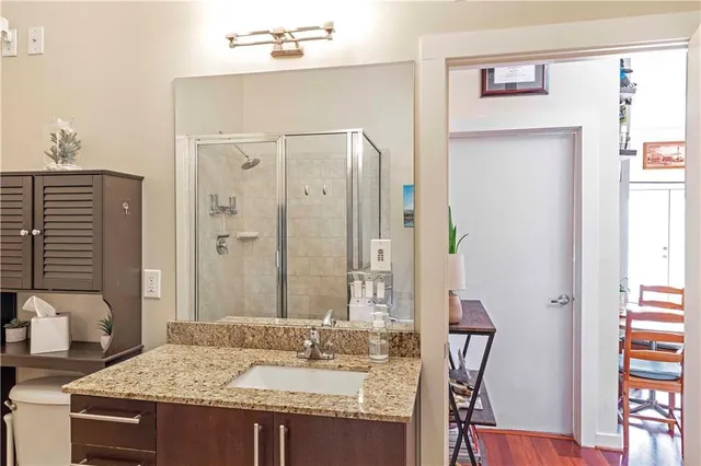 a bathroom with a granite countertop sink a mirror and a shower