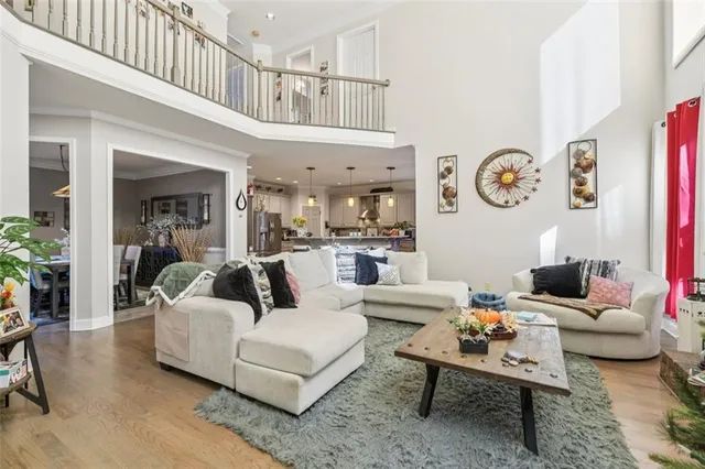 a view of a dining room and livingroom with furniture wooden floor a chandelier