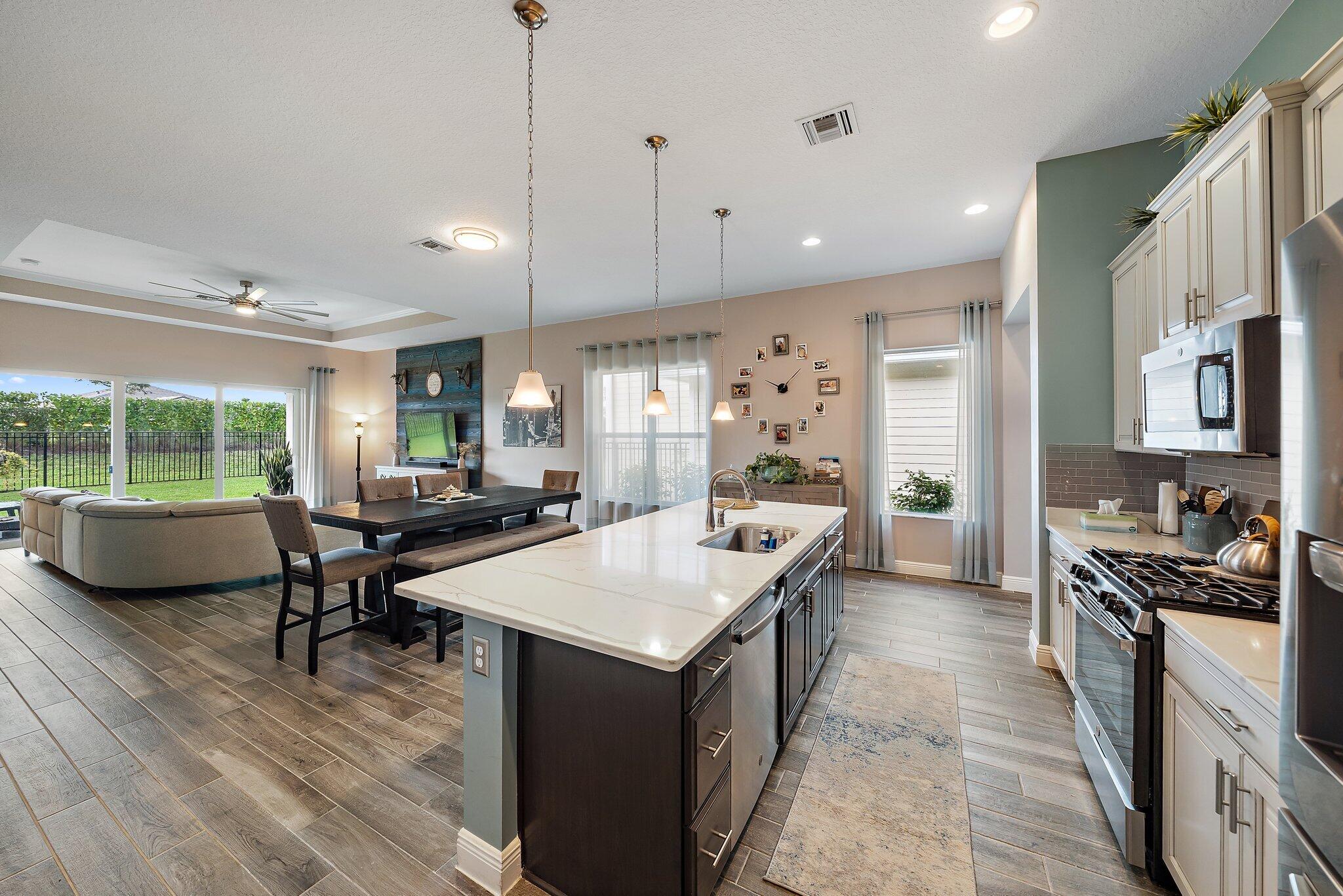 19540 Wheelbarrow Bend Loxahatchee, FL 33470 - Photo 10 of 54 a kitchen with stainless steel appliances granite countertop a stove a refrigerator a kitchen island a sink and a refrigerator