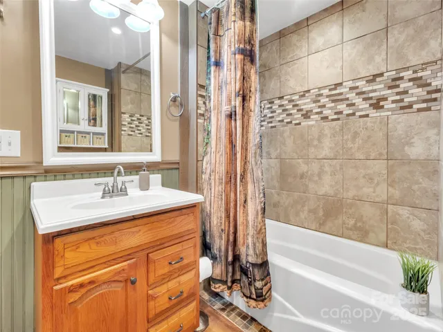 a bathroom with a granite countertop sink a mirror and a bathtub