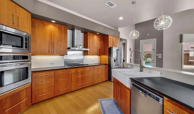 a kitchen with stainless steel appliances granite countertop a sink stove and refrigerator