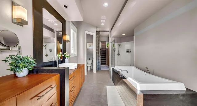 a bathroom with a tub sink and mirror