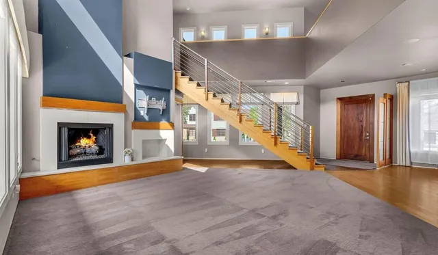 a view of an empty room with wooden floor fireplace and a window