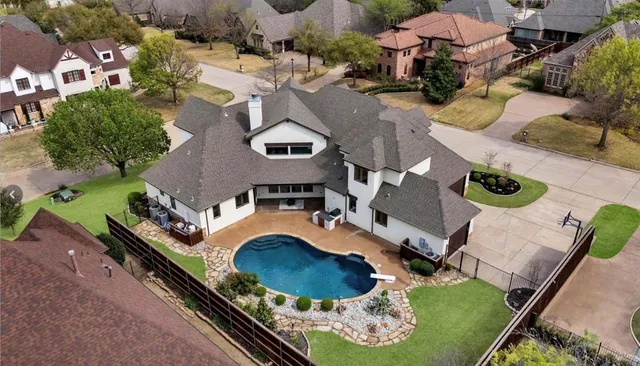 a view of pool with lawn chairs and plants