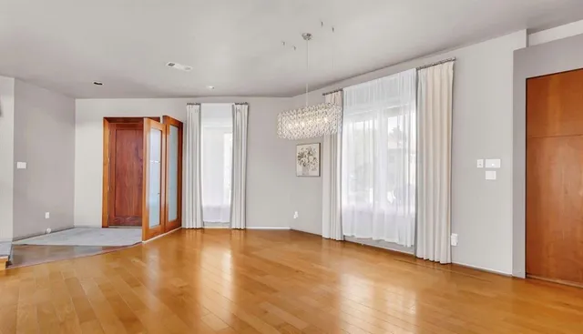 a view of an empty room with window and bathroom
