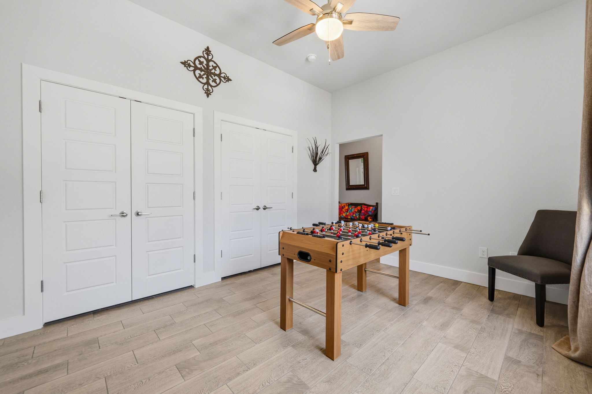 18605 Masters Cove Point Venture, TX 78645 - Photo 4 of 40 Spacious room featuring light wood-finish flooring, a ceiling fan with integrated lighting, and multiple paneled doors