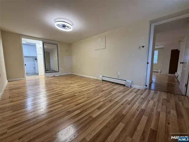 a view of empty room with wooden floor