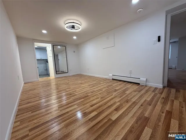 a view of empty room with wooden floor