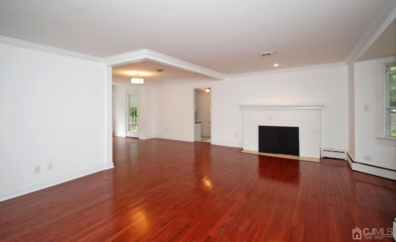 82 Red Valley Road Millstone Township, NJ 08510 - Photo 8 of 26 an empty room with wooden floor and fireplace