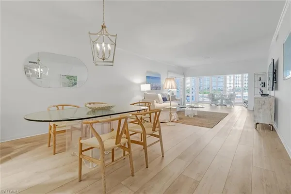 a view of a dining room with furniture a chandelier and wooden floor