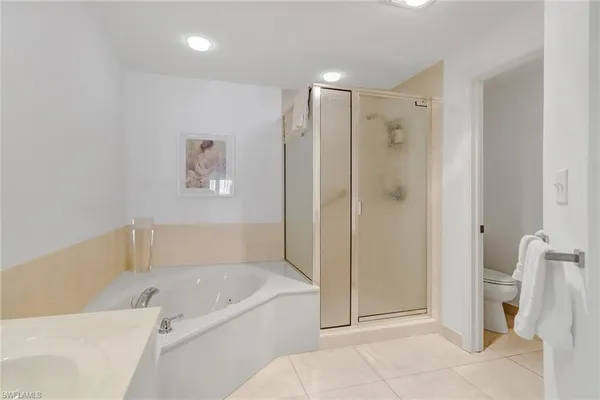 a bathroom with a tub shower and toilet