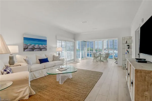 a living room with furniture a flat screen tv and wooden floor