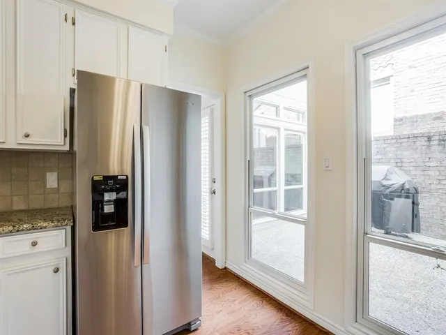 a metallic refrigerator freezer sitting in a kitchen