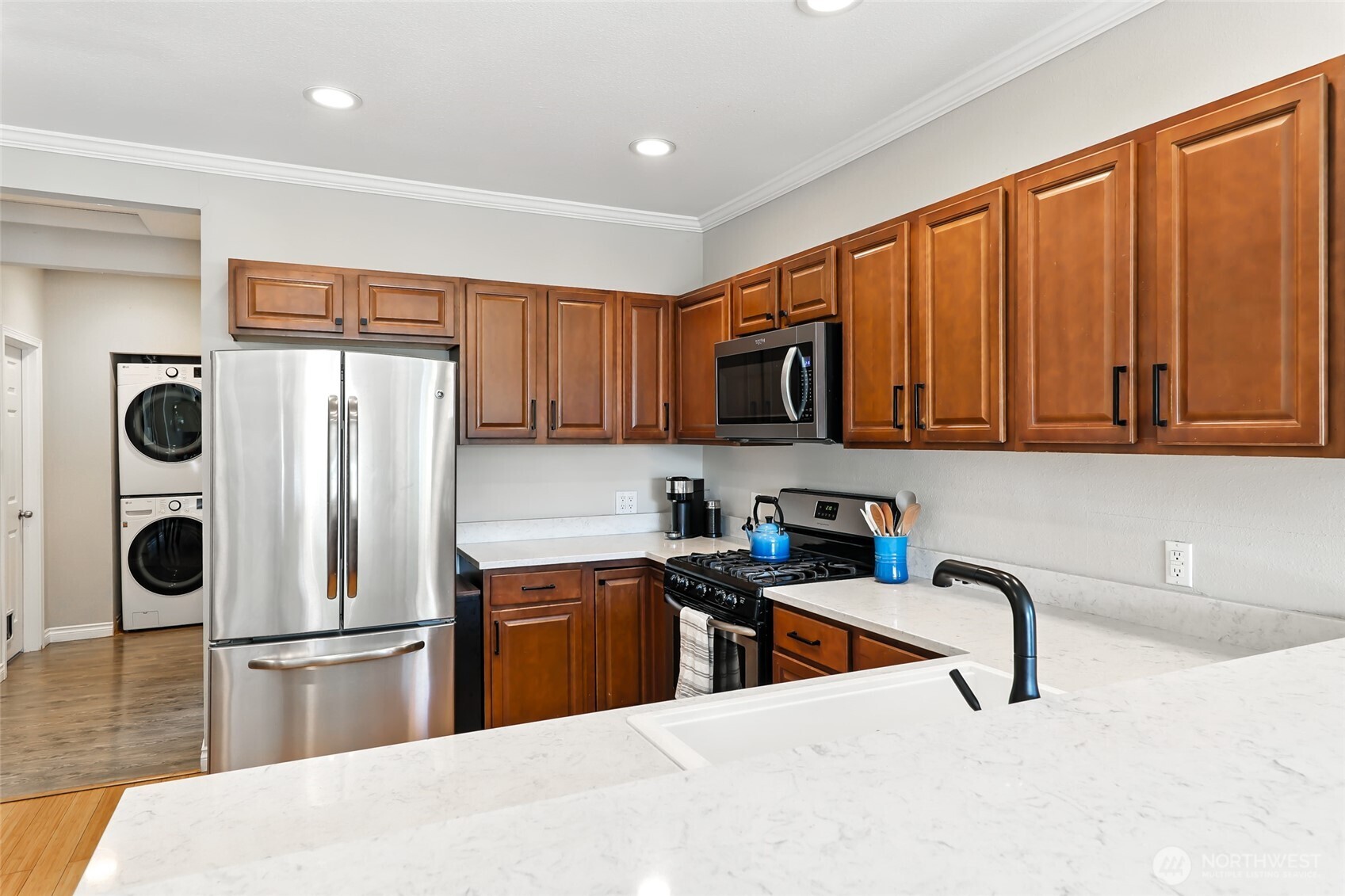 4616 South Orcas Street Seattle, WA 98118 - Photo 11 of 37 a kitchen with stainless steel appliances granite countertop a refrigerator a stove and a sink with wooden cabinets