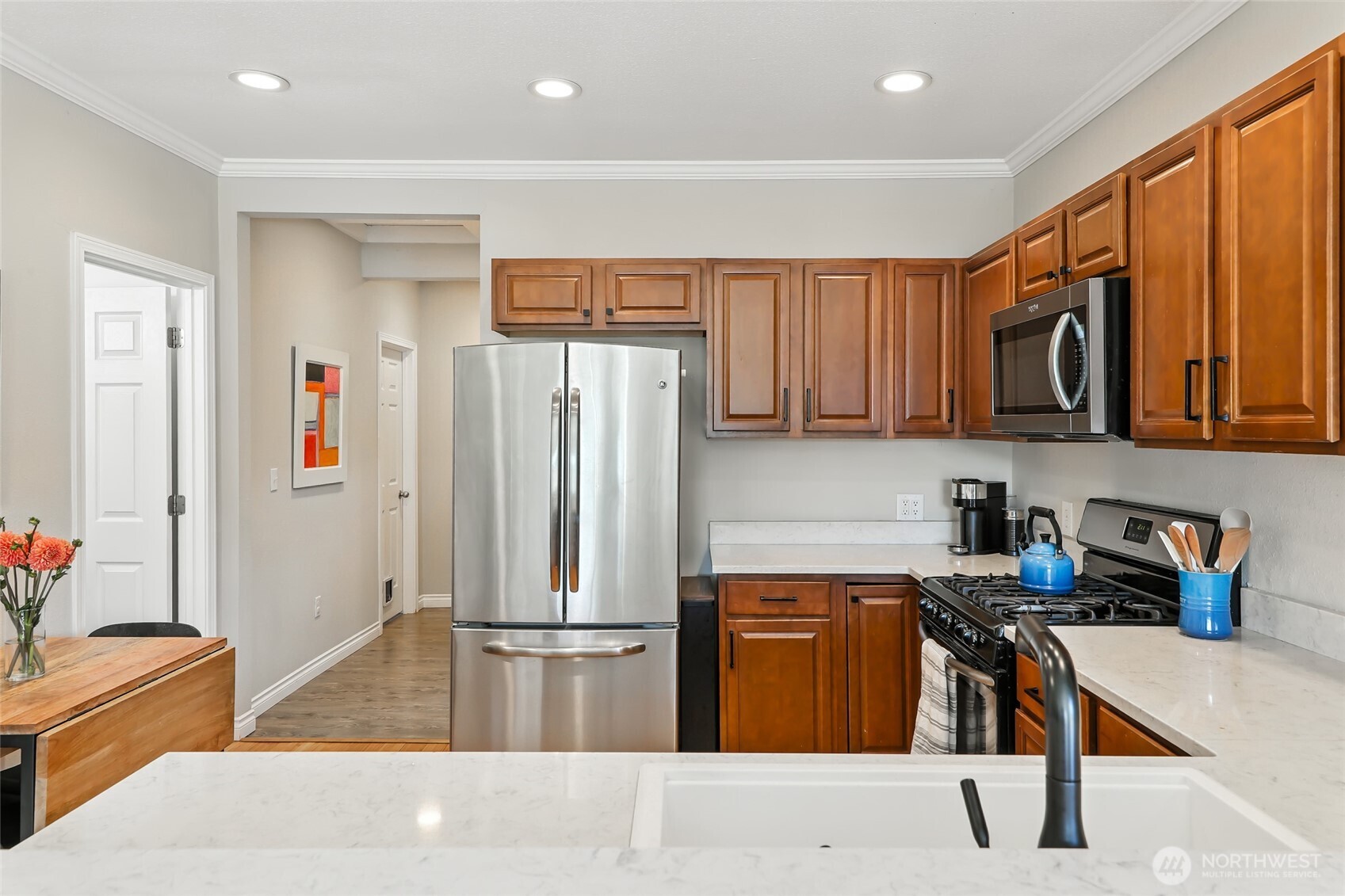 4616 South Orcas Street Seattle, WA 98118 - Photo 12 of 37 a kitchen with stainless steel appliances kitchen island granite countertop a refrigerator and a sink