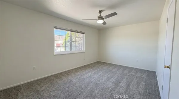an empty room with windows and fan