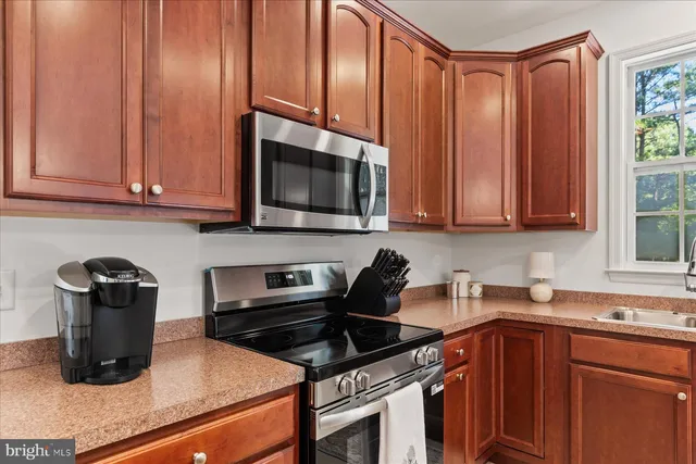 a kitchen with stainless steel appliances granite countertop a sink stove and microwave