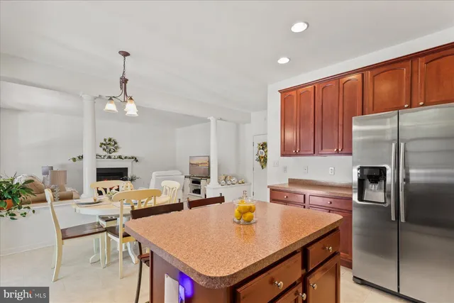 a open kitchen with stainless steel appliances granite countertop a dining table and chairs