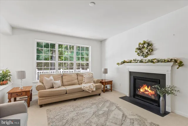 a living room with furniture a fireplace and a large window