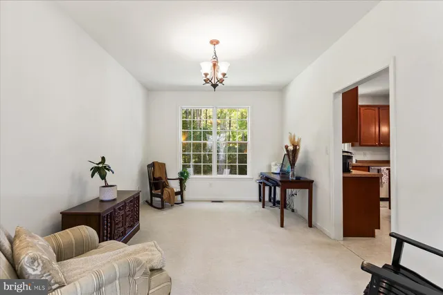 a living room with furniture two window and a chandelier