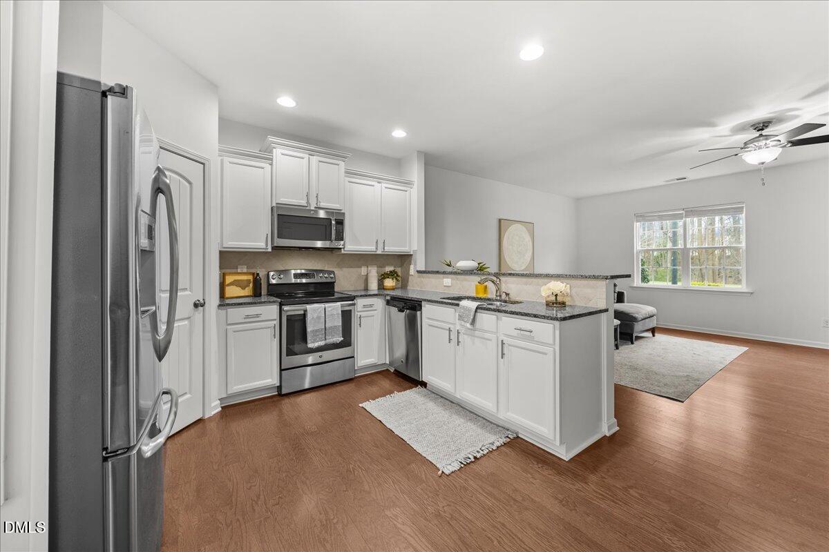 1003 Ileagnes Road Raleigh, NC 27603 - Photo 13 of 42 a kitchen with granite countertop a refrigerator stove top oven and sink
