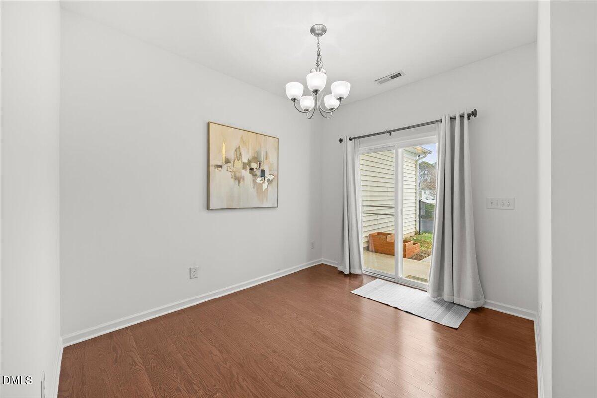 1003 Ileagnes Road Raleigh, NC 27603 - Photo 15 of 42 an empty room with wooden floor and windows