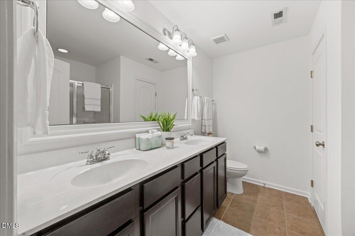 1003 Ileagnes Road Raleigh, NC 27603 - Photo 21 of 42 a bathroom with a sink double vanity granite and a mirror
