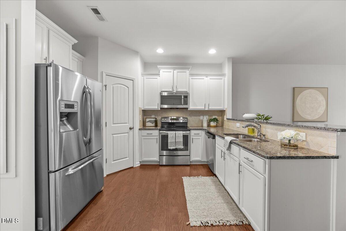 1003 Ileagnes Road Raleigh, NC 27603 - Photo 5 of 42 a kitchen with stainless steel appliances granite countertop a refrigerator stove and sink