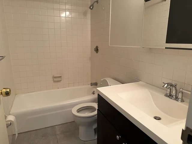 a bathroom with a granite countertop sink a toilet and bathtub