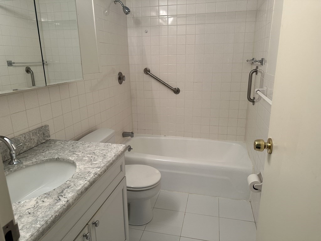 2 Summit Drive, Unit 21 Wakefield, MA 01880 - Photo 14 of 19 a bathroom with a granite countertop sink a toilet and bathtub