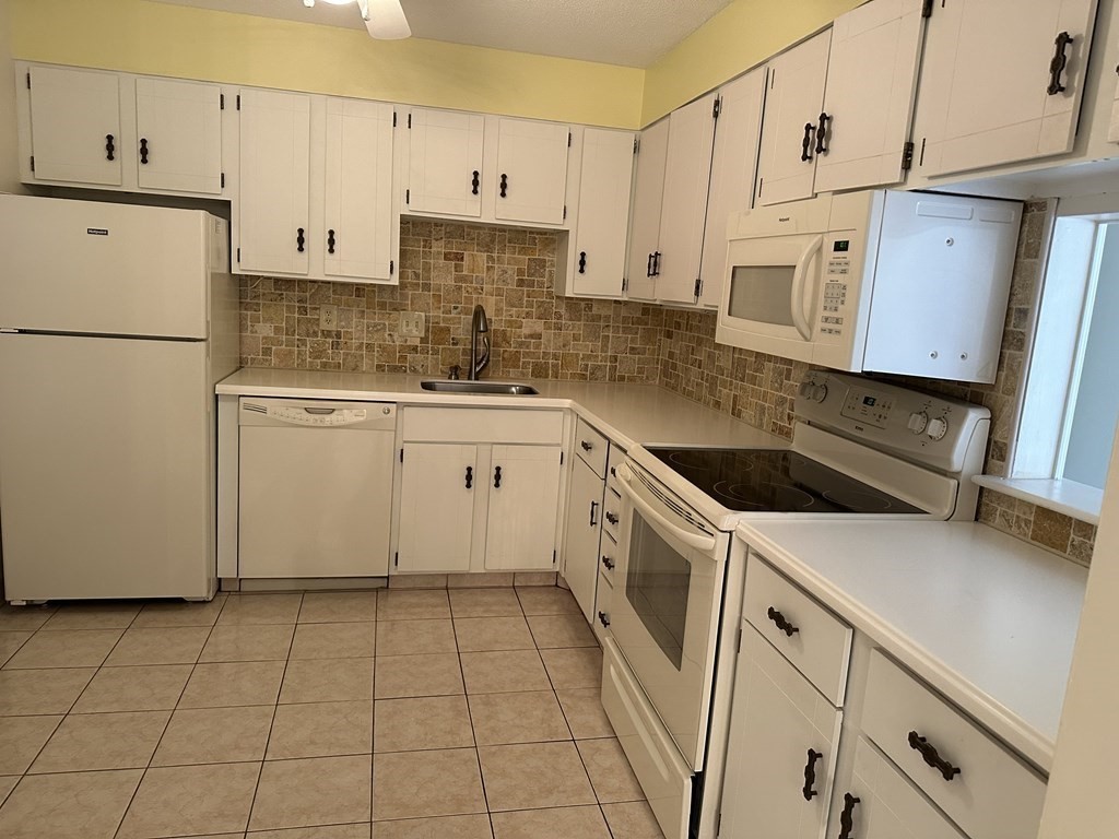 2 Summit Drive, Unit 21 Wakefield, MA 01880 - Photo 9 of 19 a kitchen with a sink a stove and white cabinets