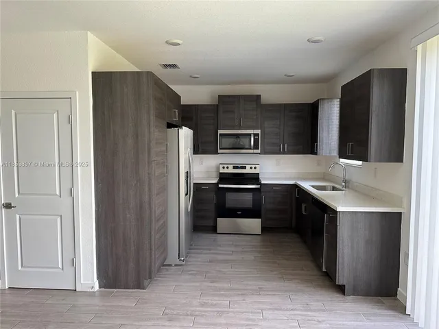 a kitchen with stainless steel appliances a refrigerator stove and sink