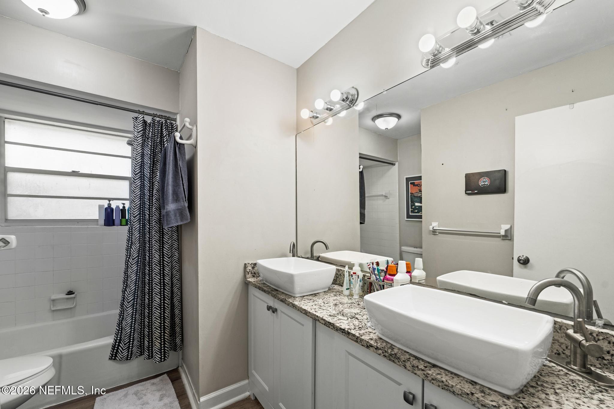 5628 Fort Sumter Road Jacksonville, FL 32210 - Photo 12 of 45 a bathroom with a bathtub a sink and a mirror