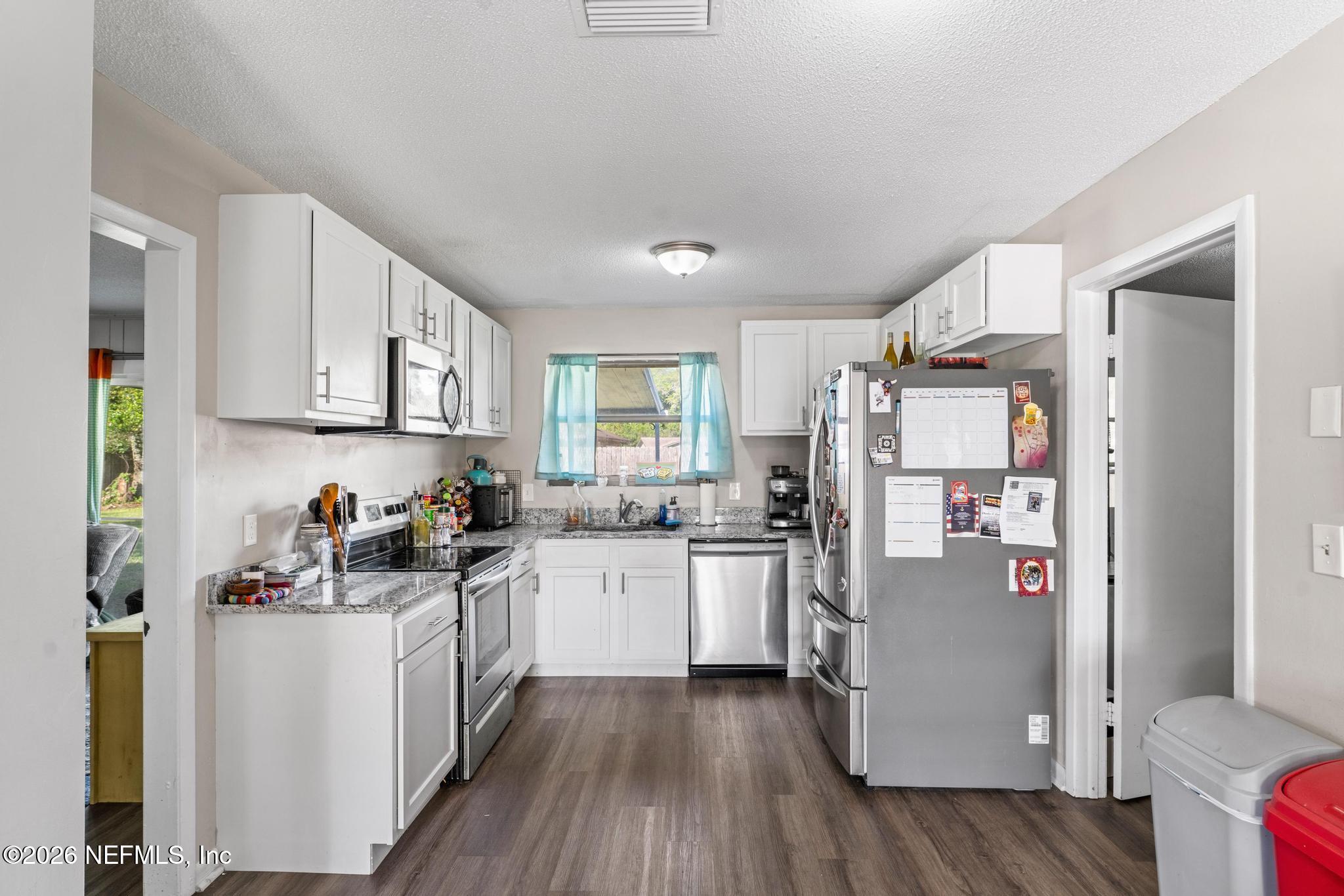 5628 Fort Sumter Road Jacksonville, FL 32210 - Photo 24 of 45 a kitchen with sink a refrigerator and white cabinets
