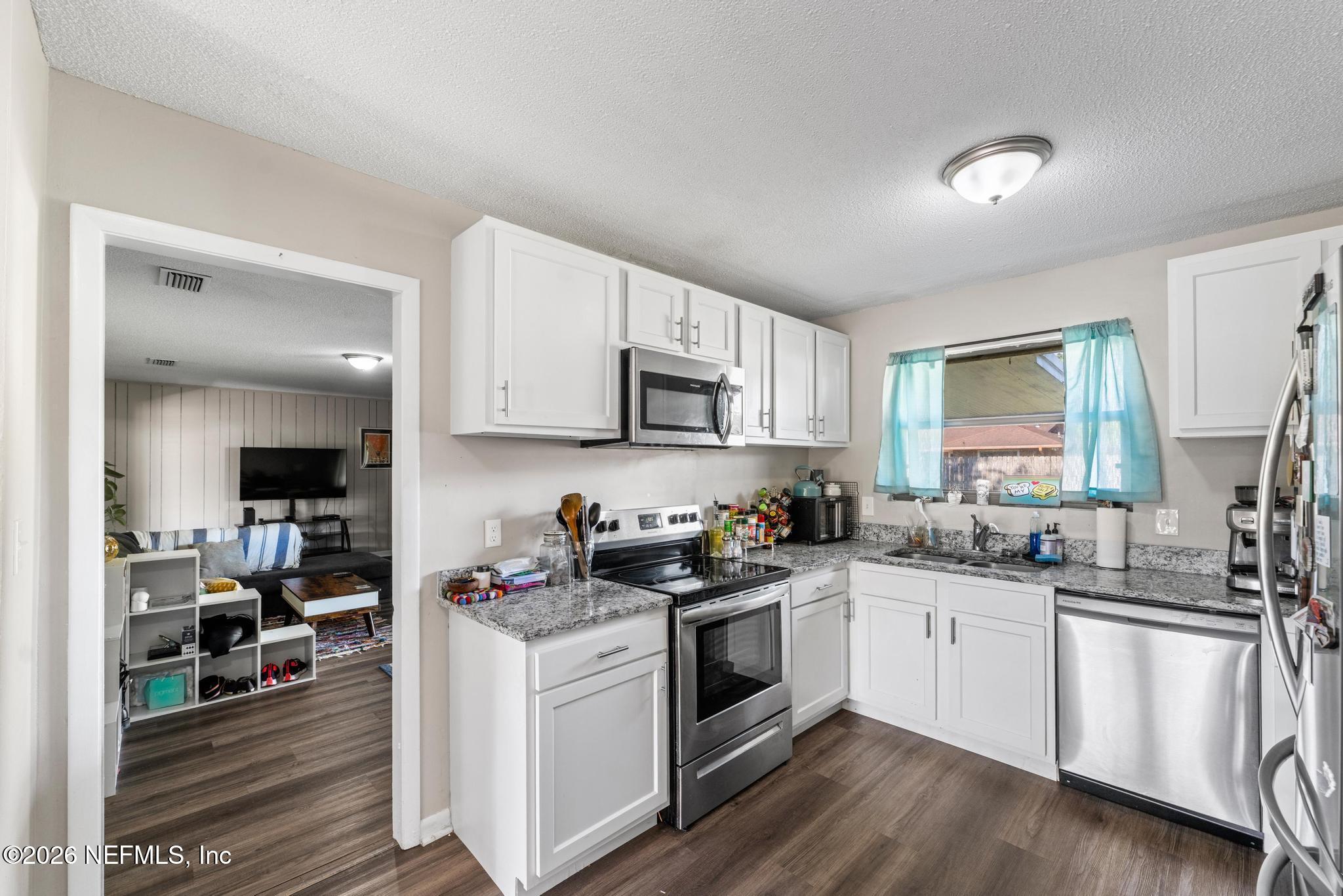 5628 Fort Sumter Road Jacksonville, FL 32210 - Photo 25 of 45 a kitchen with white cabinets sink and appliances