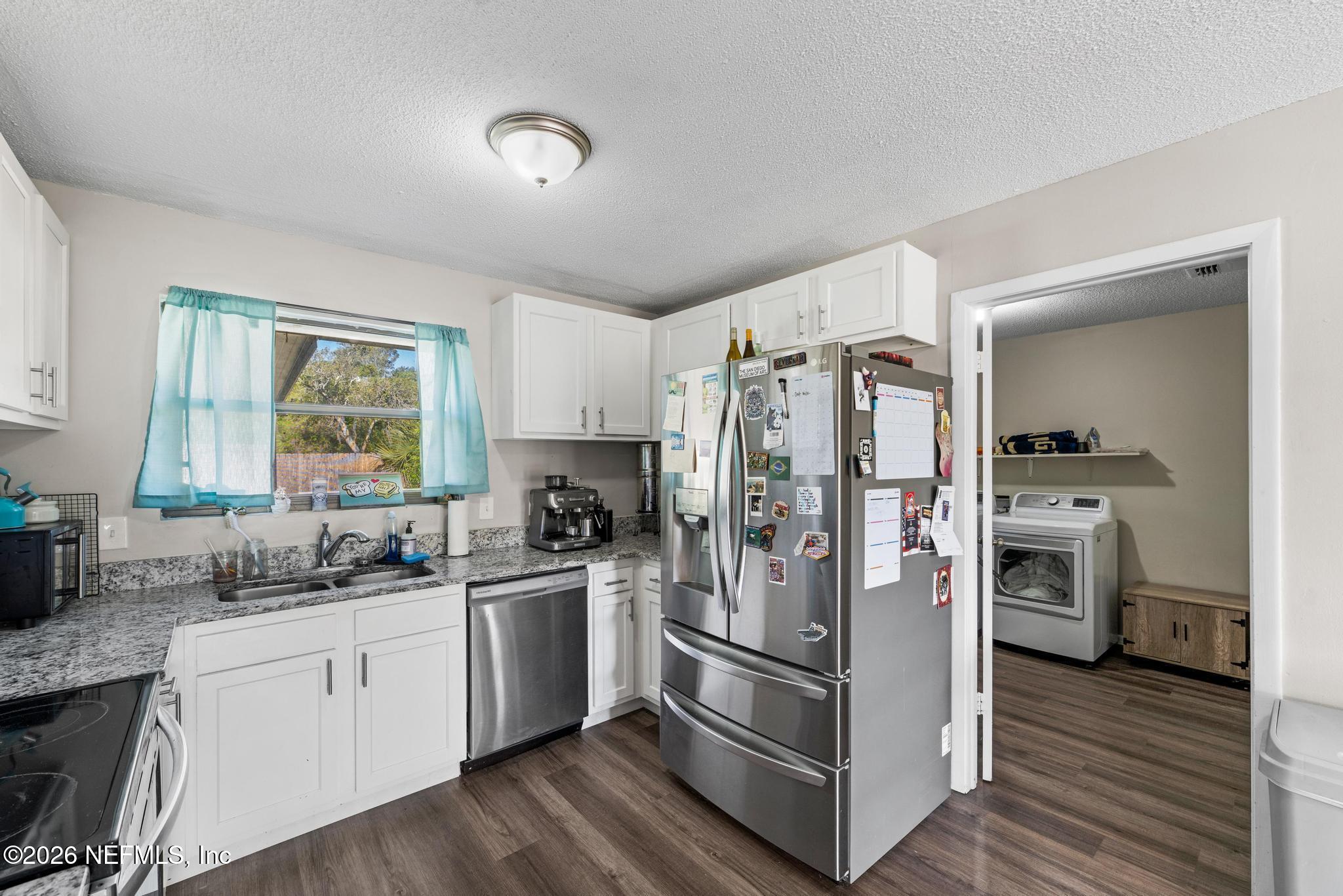 5628 Fort Sumter Road Jacksonville, FL 32210 - Photo 26 of 45 a kitchen with a refrigerator a sink cabinets and wooden floor