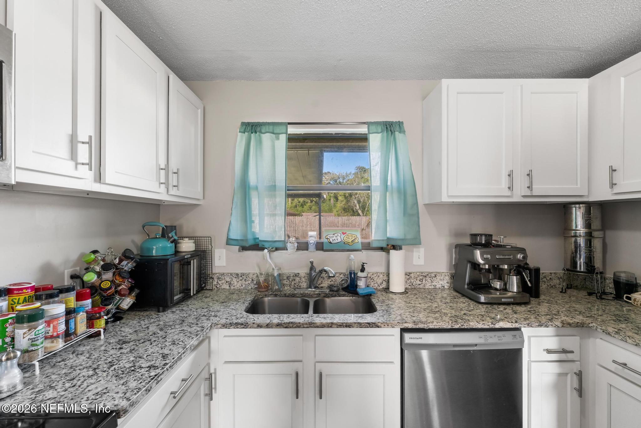 5628 Fort Sumter Road Jacksonville, FL 32210 - Photo 27 of 45 a kitchen with stainless steel appliances granite countertop a sink stove and white cabinets