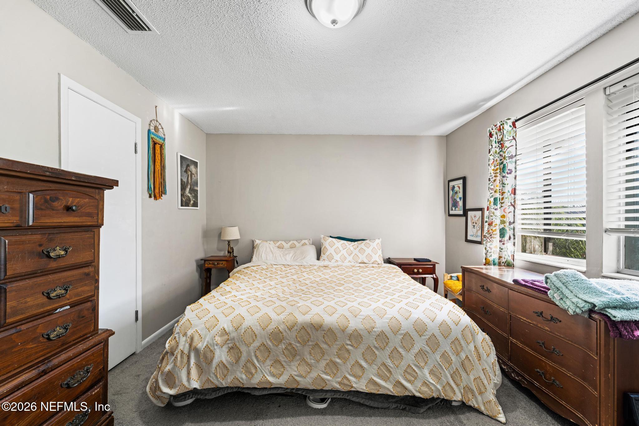 5628 Fort Sumter Road Jacksonville, FL 32210 - Photo 10 of 45 a bedroom with a bed and a large window