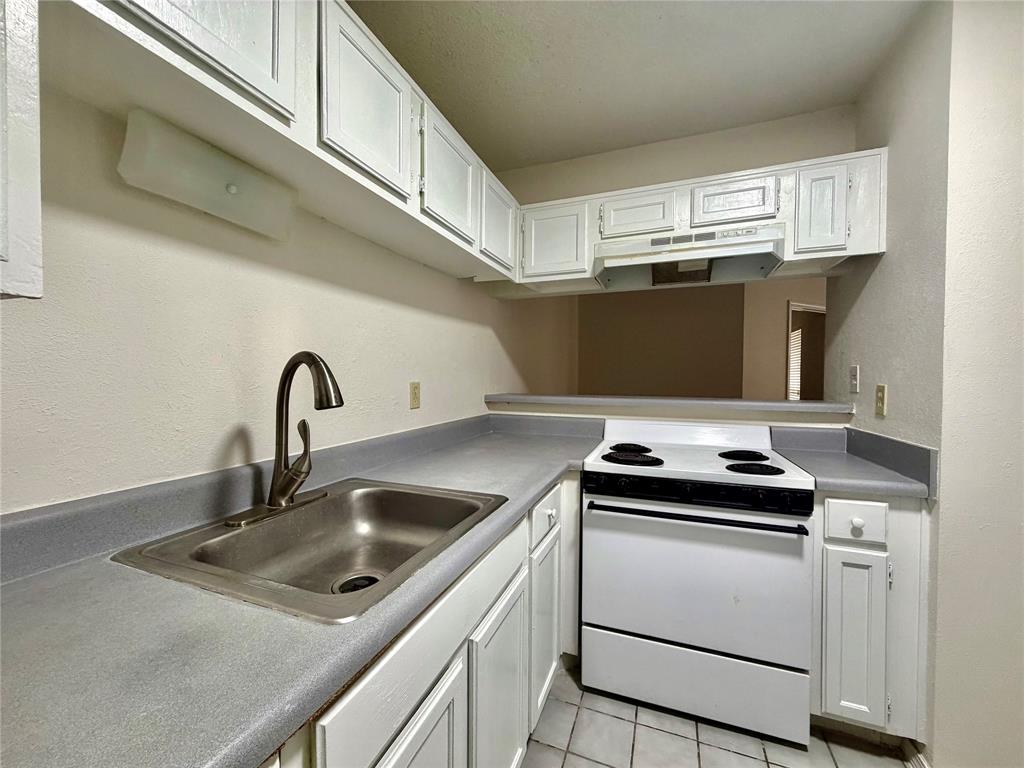 18333 Roehampton Drive, Unit 624 Dallas, TX 75252 - Photo 17 of 39 a kitchen with a stove and a sink