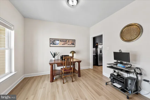 a view of a workspace with furniture and a window